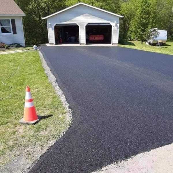 Image of a paved driveway infront of an open garage