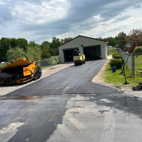 Image of people on paving a long driveway infront of a double garage 